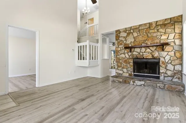 a view of empty room with fireplace and wooden floor