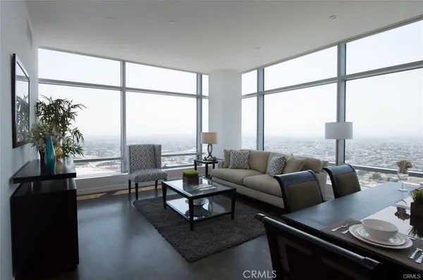 a living room with furniture and floor to ceiling windows