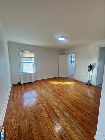 a view of a room with wooden floor and window