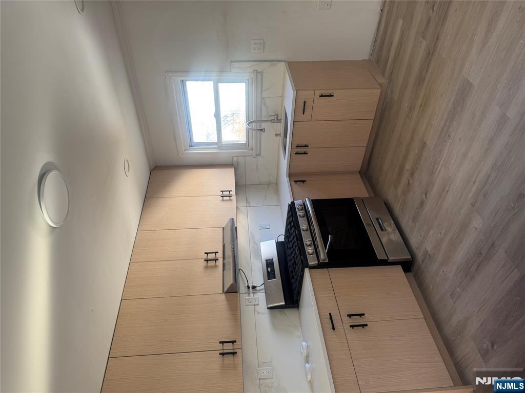 323 Devon Street, Unit 2 Kearny, NJ 07032 - Photo 6 of 8 a kitchen with stainless steel appliances granite countertop a stove a sink and white cabinets