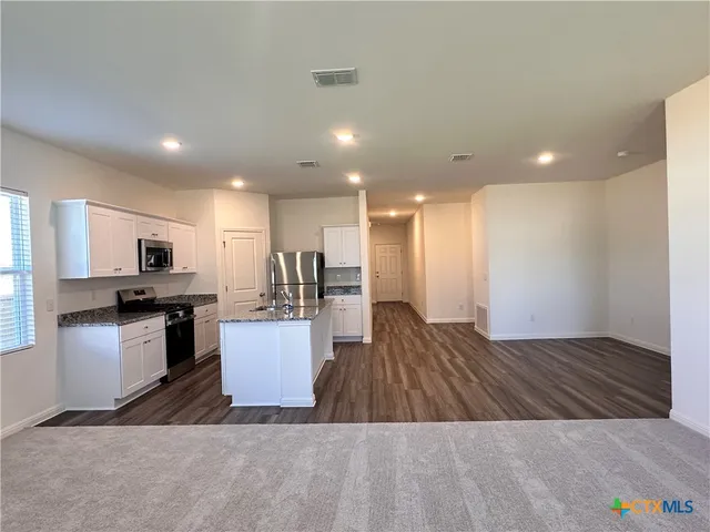 a kitchen with kitchen island wooden cabinets and stainless steel appliances
