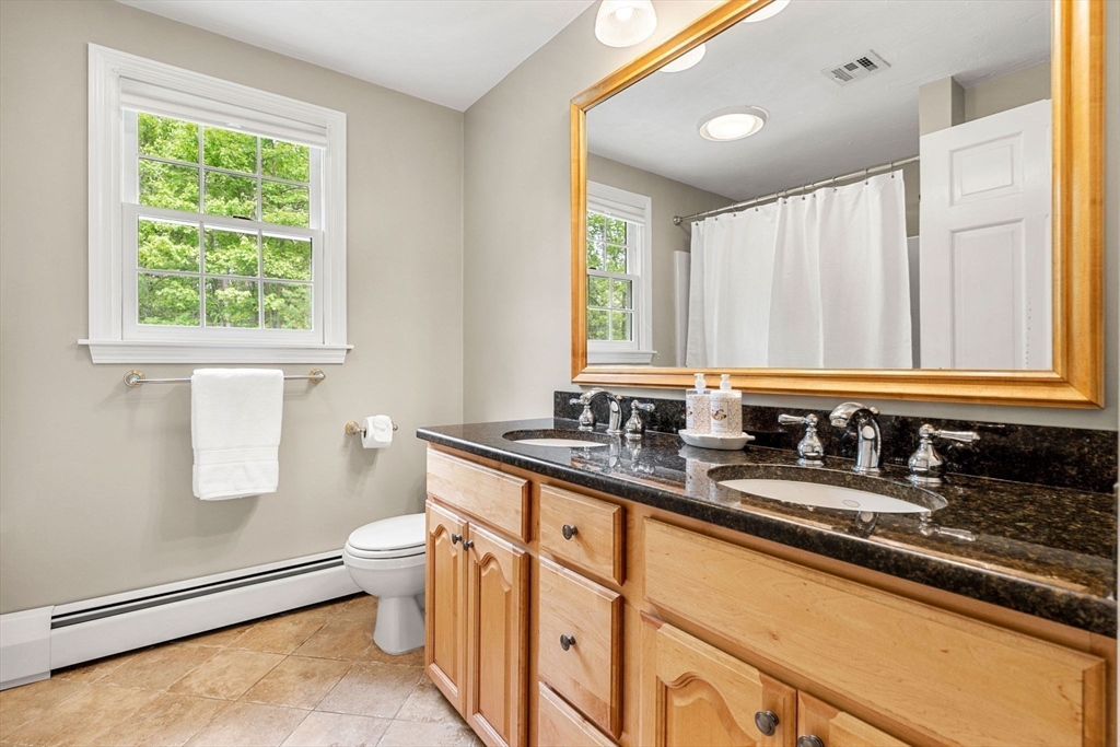 28 Charles Road Groton, MA 01450 - Photo 29 of 42 a bathroom with a granite countertop sink a toilet a mirror and a window