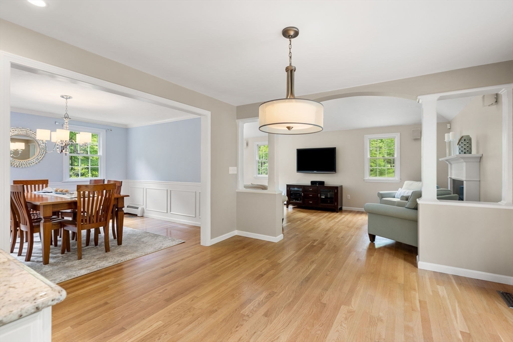 28 Charles Road Groton, MA 01450 - Photo 10 of 42 a view of a dining room and livingroom with furniture wooden floor a chandelier
