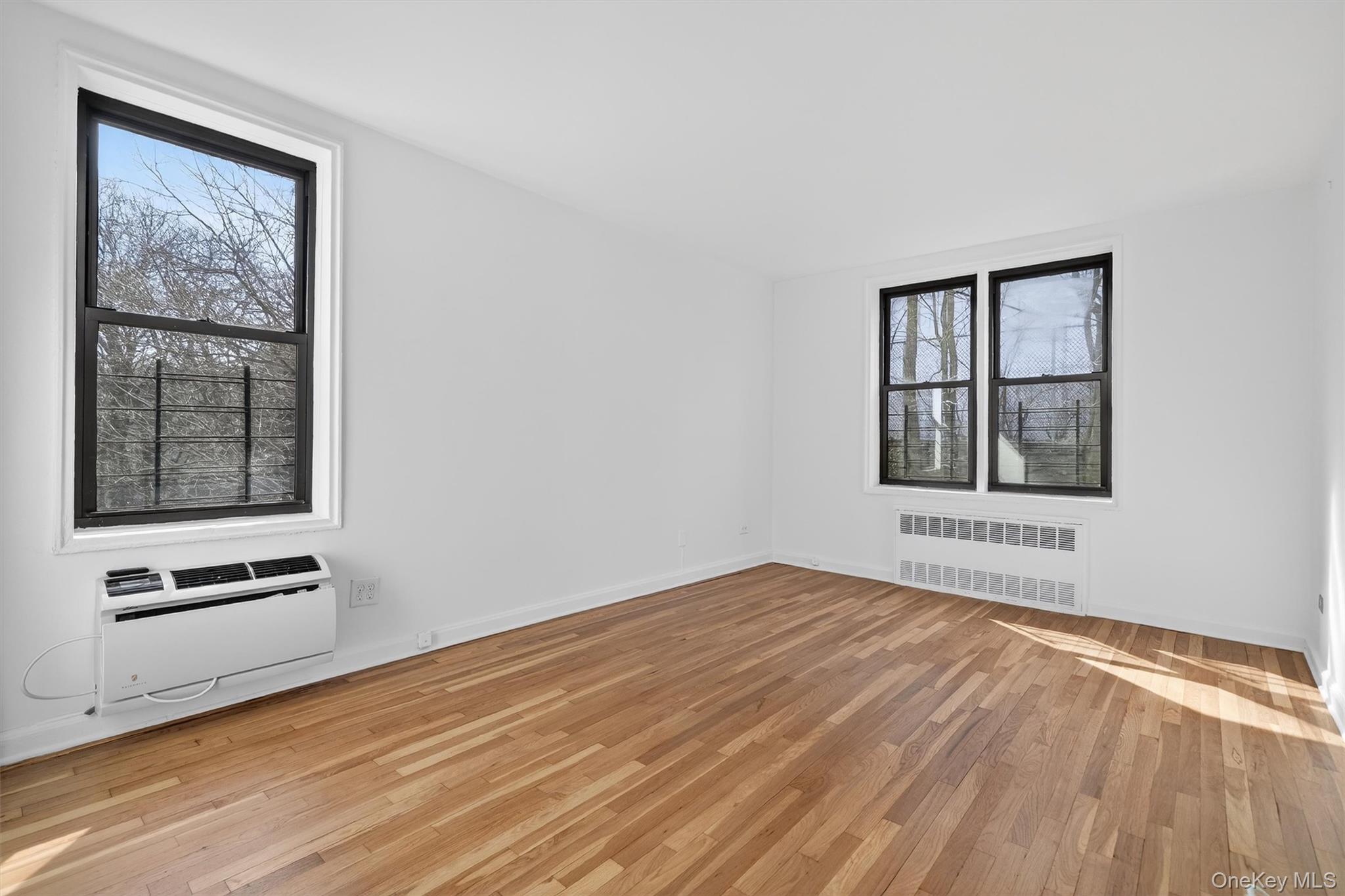5235 Post Road, Unit 5A Bronx, NY 10471 - Photo 20 of 23 a view of an empty room with wooden floor and a window