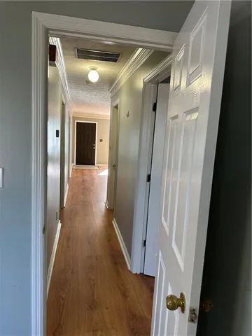 a view of a hallway with wooden floor and staircase