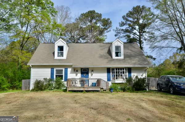 a front view of a house with a garden and trees