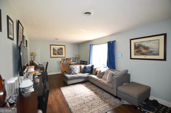 a living room with furniture wooden floor and a flat screen tv