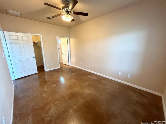 a view of an empty room and a ceiling fan