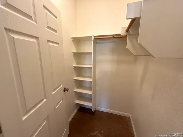 a view of walk in closet with empty racks