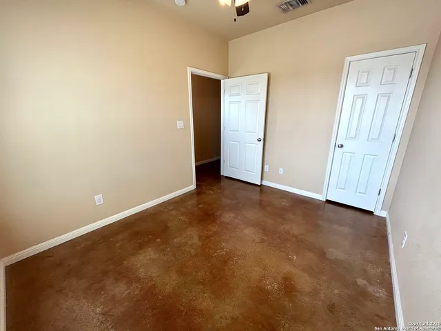 an empty room with closet and mirror