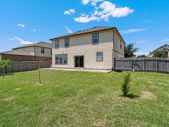 904 Lonesome Lilly Way Pflugerville, TX 78660 - Photo 34 of 34 The property features a spacious rear yard with a lawn, a concrete patio, and a wooden fence