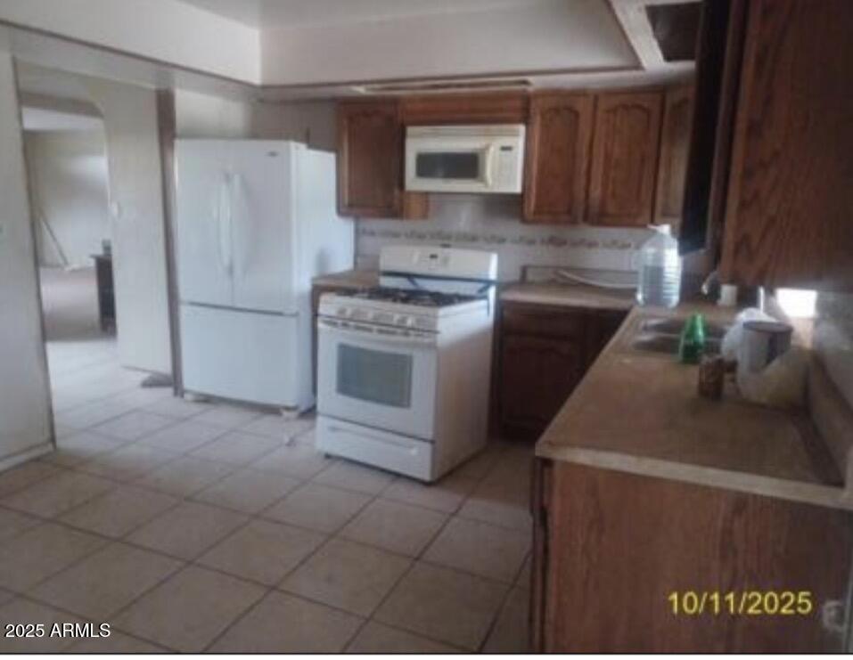 460 South Chase Street Douglas, AZ 85607 - Photo 3 of 8 a kitchen with a stove a microwave and a refrigerator