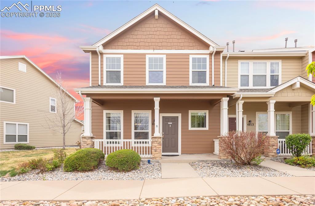 4815 Harrier Ridge Drive Colorado Springs, CO 80916 - Photo 2 of 33 Craftsman-style home with covered porch and stone siding