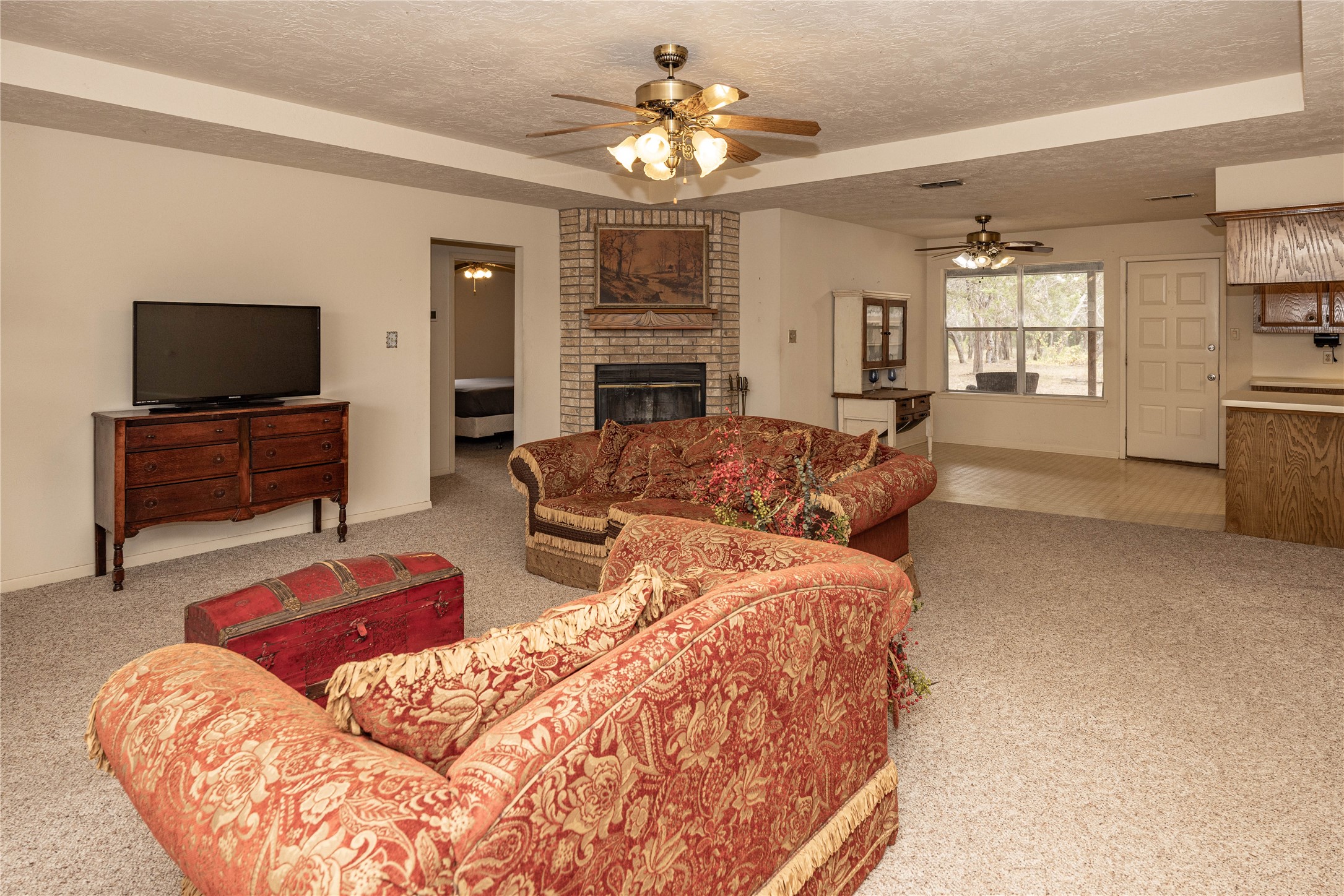 2501 Fischer Store Road Wimberley, TX 78676 - Photo 3 of 23 Spacious living area featuring light-toned carpeting and a brick fireplace