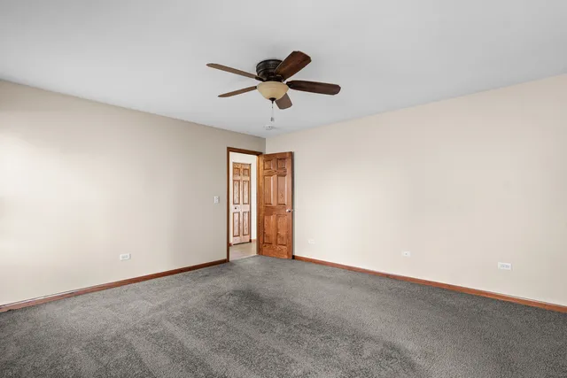 a view of an empty room and a ceiling fan