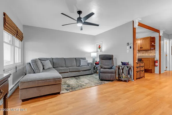 a living room with furniture a flat screen tv and a window