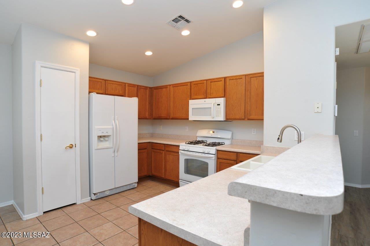 4543 South Valley Road Tucson, AZ 85714 - Photo 13 of 41 a kitchen with stainless steel appliances granite countertop a sink a stove a refrigerator and cabinets