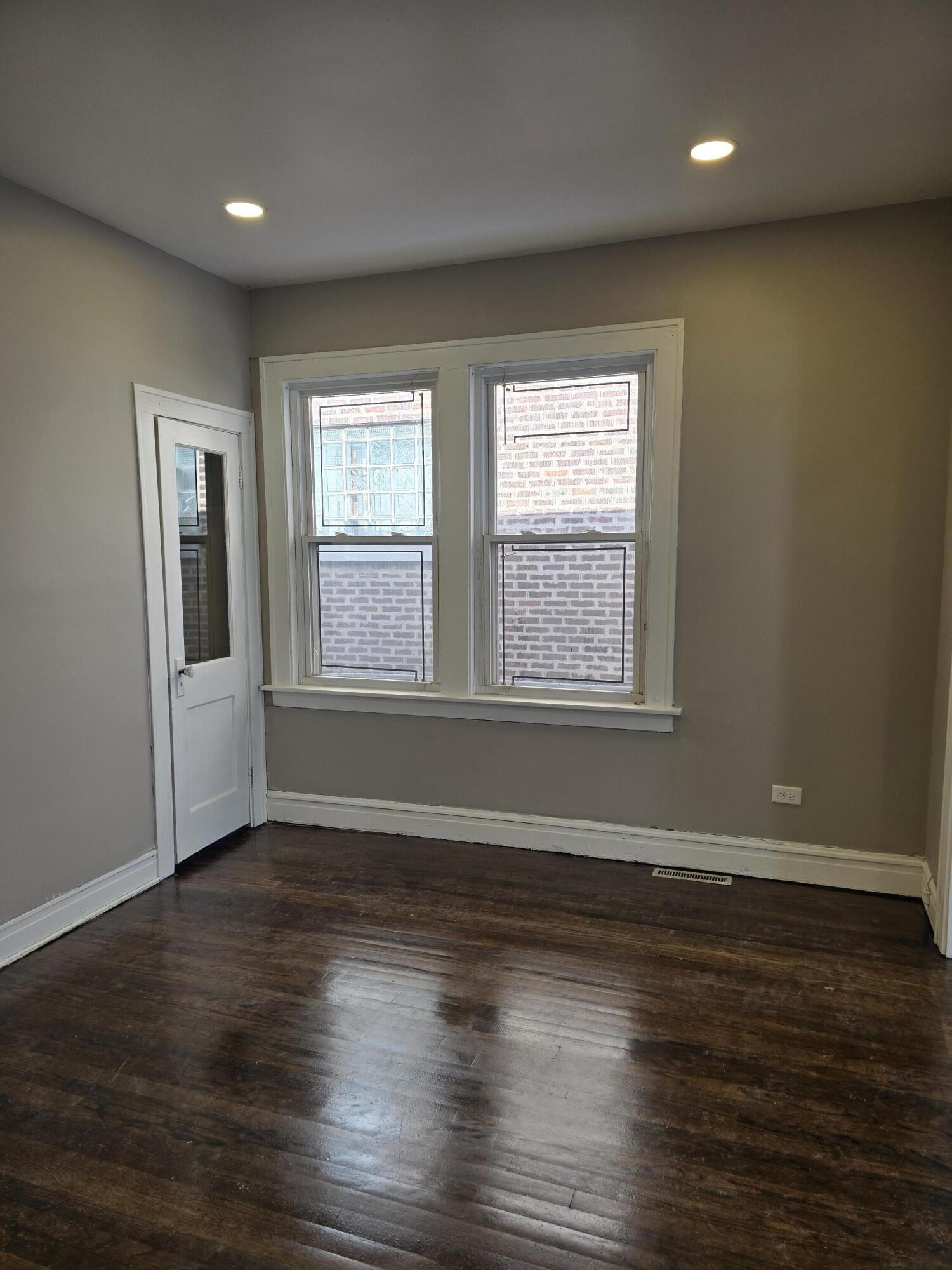 1168 Fillmore Street Gary, IN 46407 - Photo 4 of 22 an empty room with wooden floor and windows