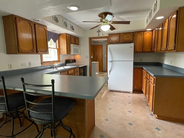 a kitchen with stainless steel appliances granite countertop a sink a stove and a refrigerator