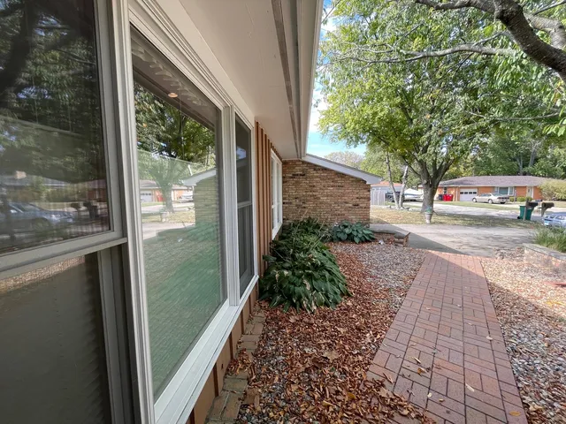 a view of a yard with a car parked beside a road