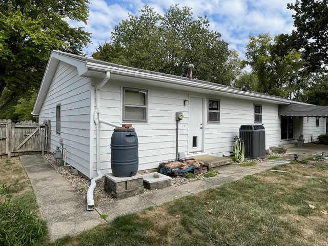 a front view of house with yard and trees in the background