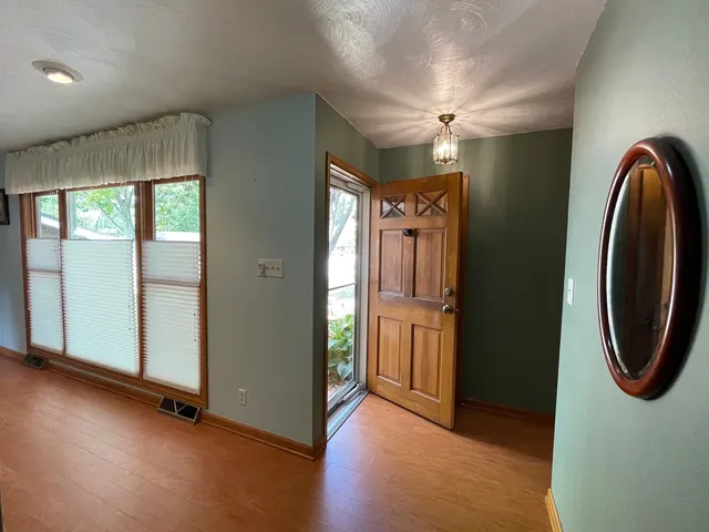 an entryway with wooden floor and windows
