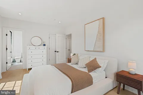 a bedroom with a bed a dresser and chair