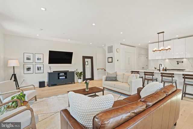 a living room with furniture a flat screen tv and kitchen view