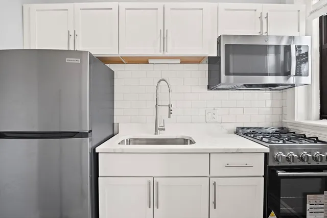 a kitchen with stainless steel appliances a refrigerator stove and microwave