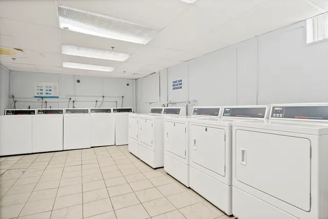 a kitchen with white cabinets a sink and white appliances