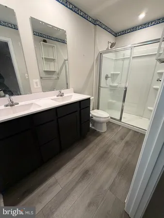 a bathroom with a double vanity sink toilet mirror and shower