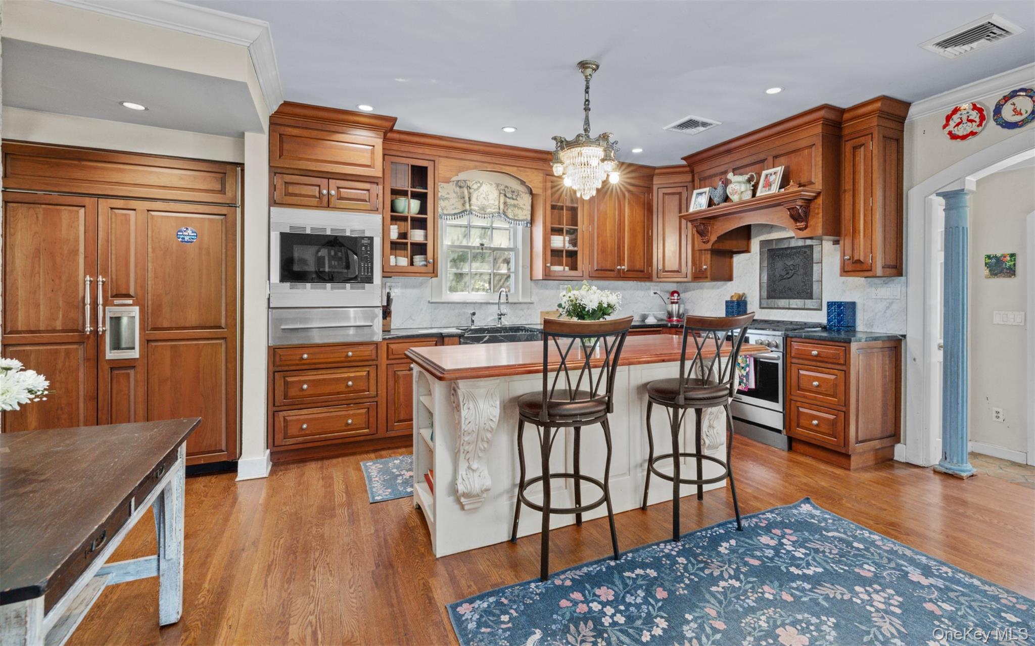 11-20 Shore Road Queens, NY 11363 - Photo 20 of 46 a kitchen with stainless steel appliances kitchen island granite countertop a refrigerator a stove top oven and a dining table with wooden floor