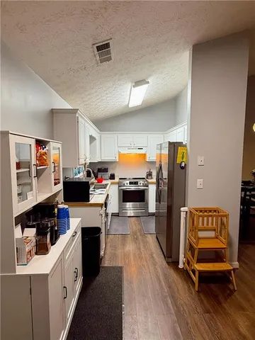 a kitchen that has a lot of cabinets a sink and appliances in it