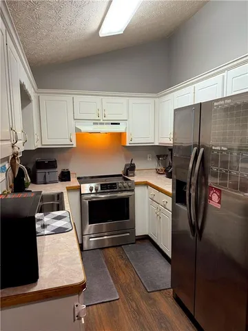 a kitchen with stainless steel appliances granite countertop a stove a sink and a refrigerator