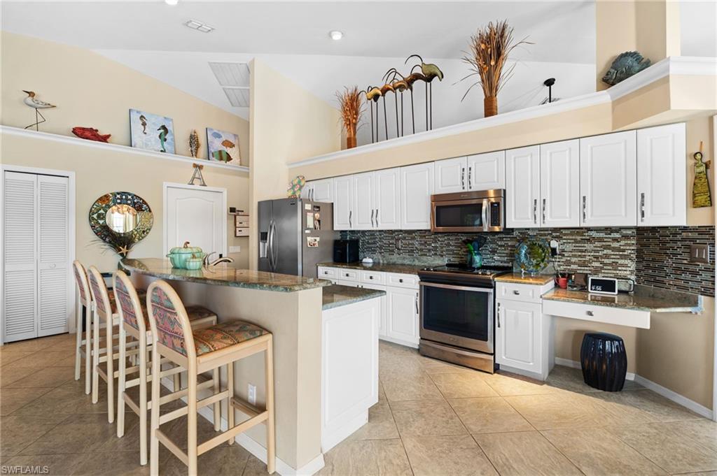200 St James Way Naples, FL 34104 - Photo 12 of 45 Kitchen featuring a breakfast bar