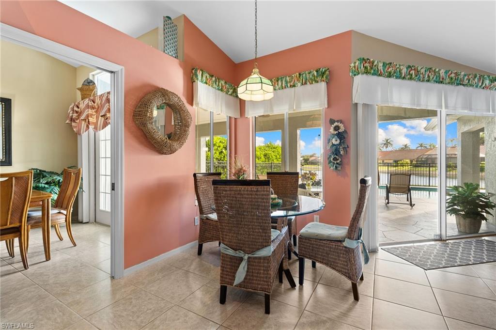 200 St James Way Naples, FL 34104 - Photo 14 of 45 Tiled dining space featuring vaulted ceiling