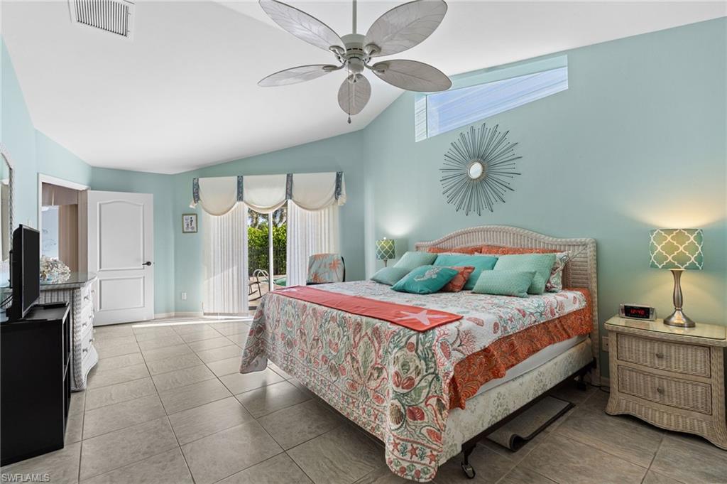 200 St James Way Naples, FL 34104 - Photo 15 of 45 Bedroom with access to exterior, tile patterned floors, a ceiling fan, and high vaulted ceiling