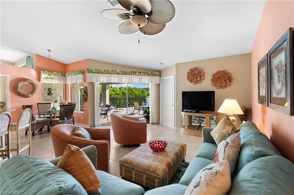 200 St James Way Naples, FL 34104 - Photo 9 of 45 Family room with tile floor and view of lake & fountain