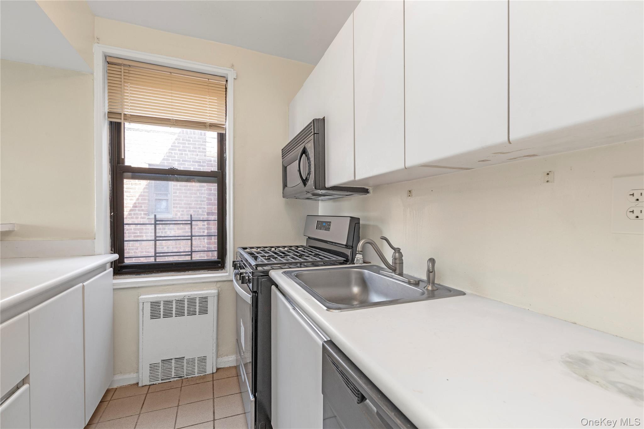 150-11 72nd Road, Unit 6E Queens, NY 11367 - Photo 5 of 13 a kitchen with stainless steel appliances granite countertop a sink and a stove