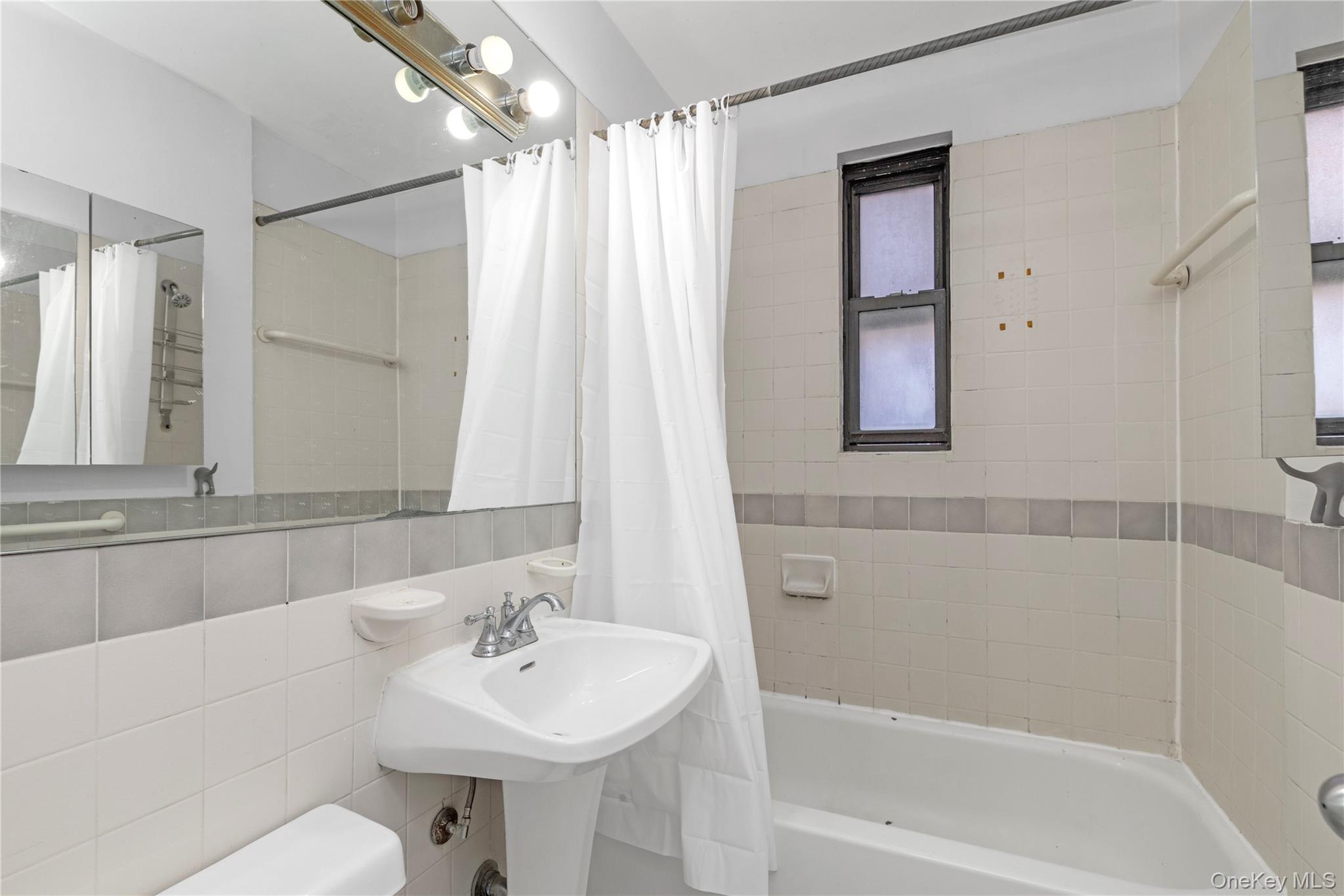 150-11 72nd Road, Unit 6E Queens, NY 11367 - Photo 8 of 13 a bathroom with a sink mirror and a bathtub