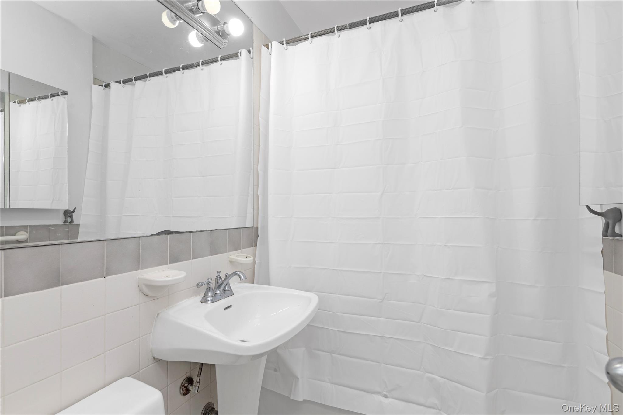 150-11 72nd Road, Unit 6E Queens, NY 11367 - Photo 9 of 13 a bathroom with a sink and a mirror