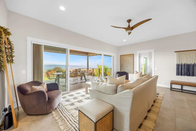 a living room with furniture a rug and kitchen view