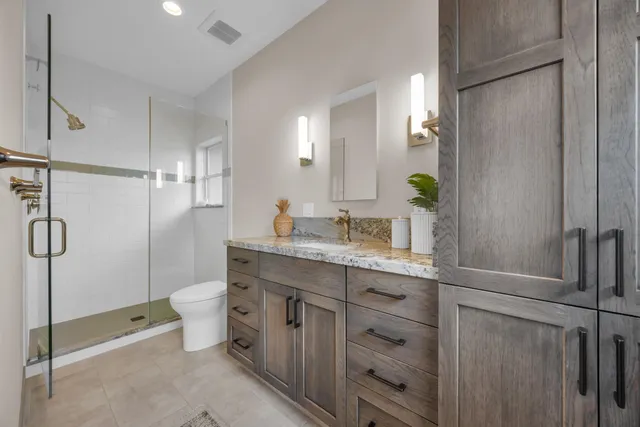 a bathroom with a sink a toilet and shower