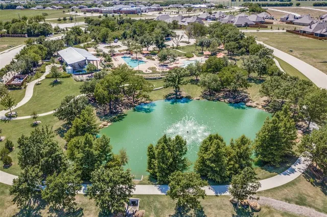 an aerial view of a house with a yard and lake view