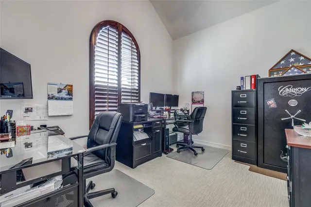 a view of a workspace with furniture and a window