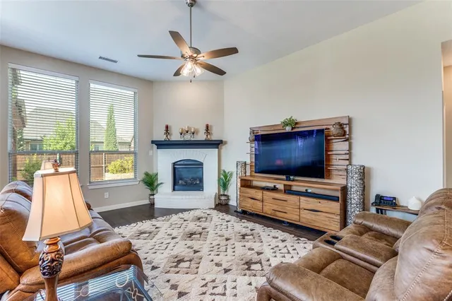 a living room with furniture a flat screen tv and a fireplace