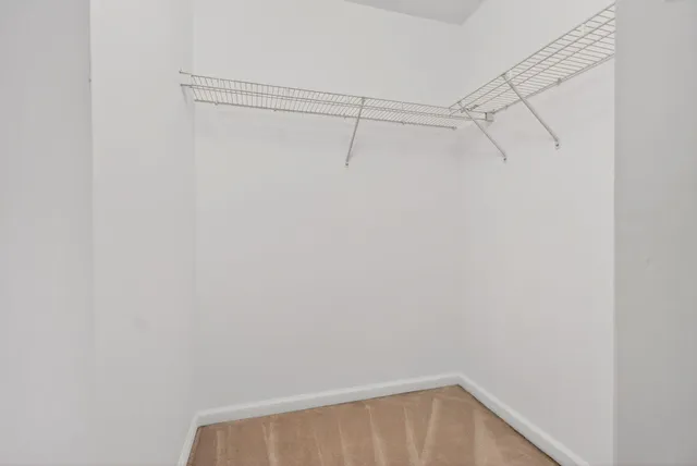 a view of empty room with wooden floor and ceiling fan