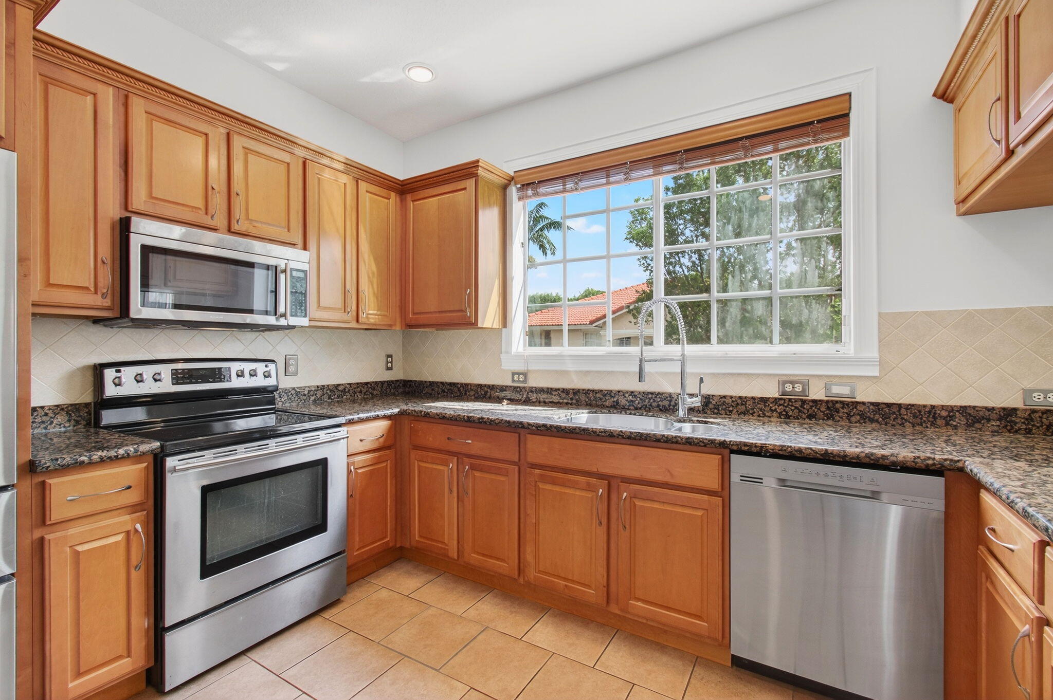 4582 Danson Way Delray Beach, FL 33445 - Photo 6 of 74 a kitchen with granite countertop cabinets stainless steel appliances a sink and a window