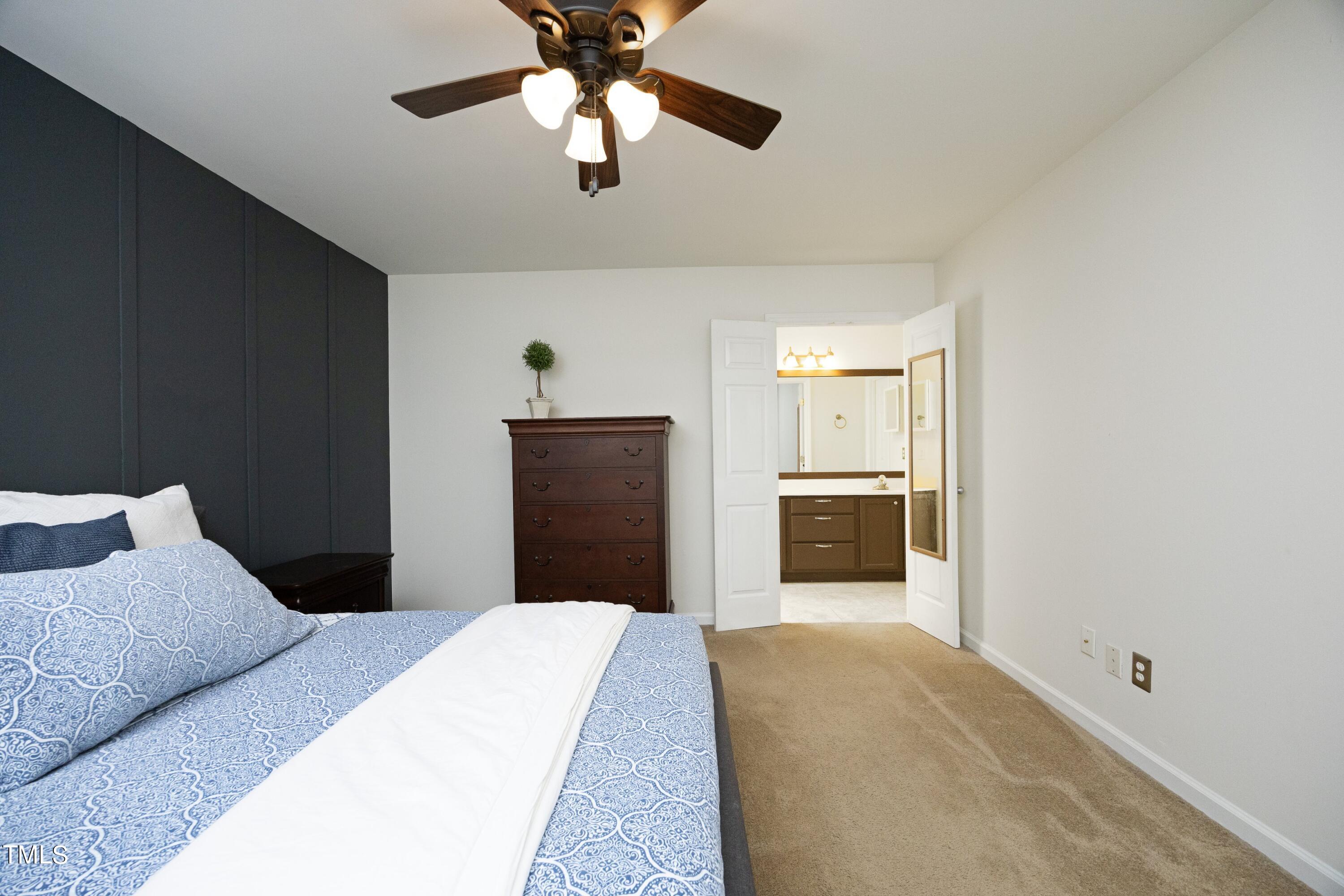 8904 Castleton Lane Raleigh, NC 27615 - Photo 20 of 43 a bedroom with a large bed and a chandelier