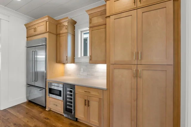 a view of an empty room with wooden floor fireplace and a window